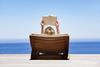 Sunbather reads book on lounger overlooking the sea
