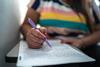 A close up shot of a woman's hand as she writes in an exam