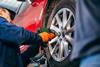 A mechanic replaces a car wheel
