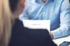 An interviewer reads a CV
