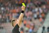 Football referree holds up yellow card