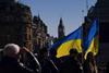 Ukrainian flags wave in Trafalgar Square as people descend to attend a protest, in London