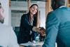 A woman smiles as she shakes hands with her client