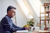 A man types on a laptop at home