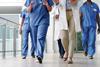 A group of doctors walk down a hospital corridor