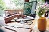 Woman types on laptop at kitchen table