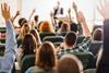 Students raise their hands in a lecture