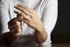 An anonymous woman removes her wedding ring