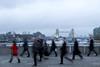 Commuters walk across London Bridge