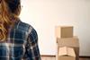 A woman looks at moving boxes