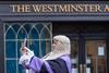 A judge stops to take a photo outside Westminster Abbey before the opening of the legal year