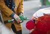A woman fills up her car at a petrol station
