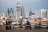 Blurred passers-by walk in front of the London City skyline