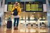 A traveller reads a flight departure board at an airport