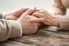 An older couple holds hands
