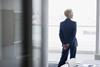 An older businesswoman looks out of an office window