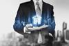 An anonymous businessman holds an image of a digital house in his hand