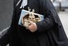 A barrister holds his wig on his way to court