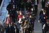 Commuters wearing masks walk through London train station