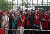 Liverpool fans cover their mouths and noses as they queue to gain entry to the Stade de France, Paris, ahead of the 2022 UEFA Champions League Final