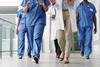 A group of doctors walk down a hospital corridor