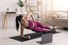 A young woman does an online pilates class