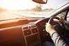 Close up shot of car dashboard with driver behind the wheel