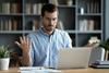 A man looks perplexed as he works on his laptop