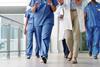 A group of doctors walk down a hospital corridor