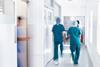 Surgeons wearing scrubs walk to theatre in hospital