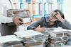 Office worker looks through piles of files