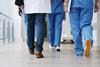Hospital staff walk down the corridor
