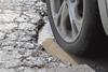A car drives through a pothole