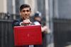 Chancellor of the Exchequer Rishi Sunak stands outside No 11 Downing Street and holds up the traditional red box that contains the budget speech