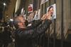 A man hangs pictures of five journalists who were murdered in Mexico in 2022