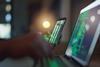 Hacker holds phone showing coding
