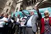Tom Hedges holds up a bottle of Prosecco as he celebrates the verdict with other former Post Office sub-postmasters outside the High Court