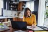 A young woman works from her kitchen table