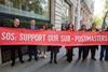 Victims of the Post Office scandal hold a banner outside the inquiry