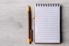 A pen and notepad next to each other on a table
