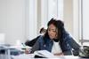 Female student writes notes while reading textbook