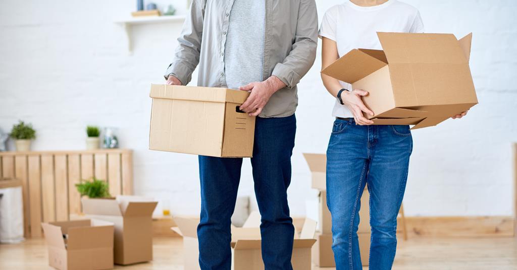 An anonymous couple carry moving boxes