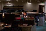 A young woman works late at night in the office