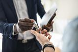 An estate agent hands house keys to a buyer