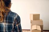 A woman looks at moving boxes