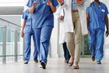 A group of doctors walk down a hospital corridor