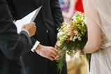 An officiant conducts a wedding ceremony with a bride and groom