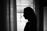 Silhouette of a woman's side profile against light from a window