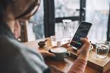 A woman looks at a stocks graph in a coffee shop