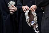 Barristers wearing gowns hold their wigs in their hands